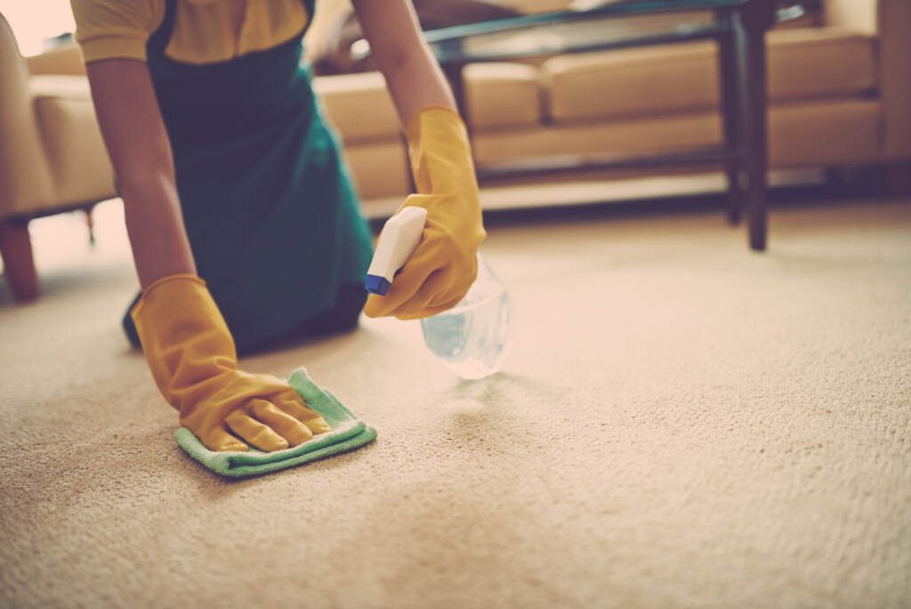 Female cleaner using spray stains remover